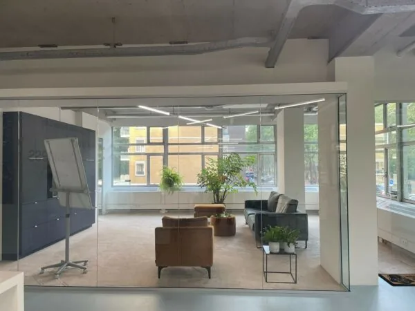 Modern ingerichte vergaderruimte aan de Van Leijenberghlaan met glazen wanden, zitmeubels en kamerplanten.